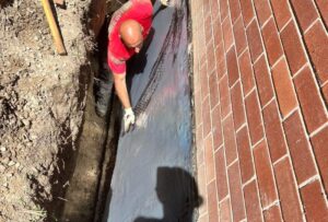 Basement waterproofing work in progress in Etobicoke with excavation around the foundation.