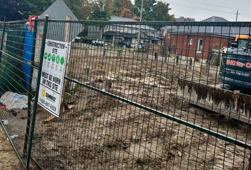 Fenced and cleared excavation site with safety signage in Toronto